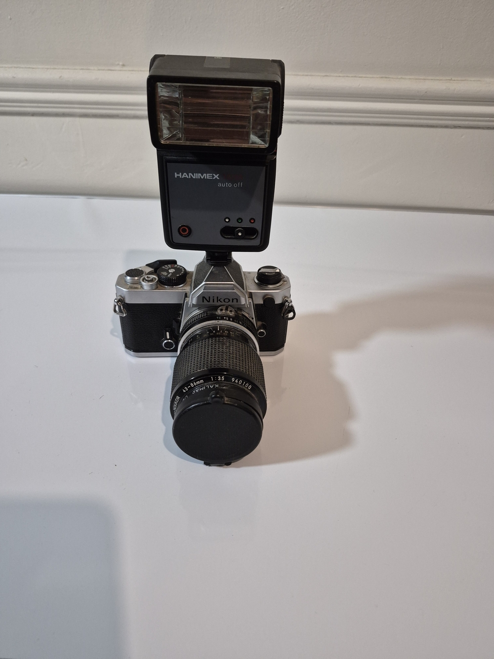 Nikon Silver and Black Film SLR with Mounted Hanimex Flash